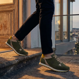 Lifestyle shot of bugatti Garnet Evo dark green leather sneakers with yellow and beige accents.
