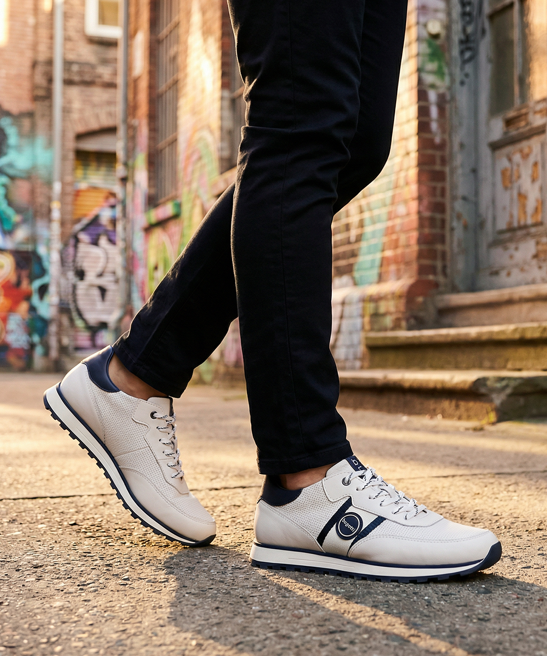 Lifestyle view of bugatti Garnet Evo white sneakers in premium leather, featuring navy accents and black pants.
