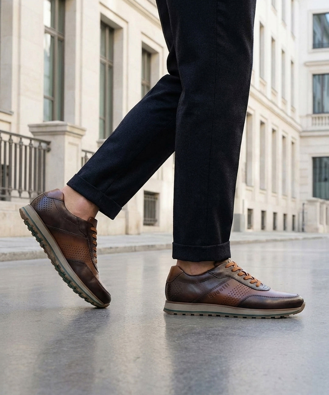 Lifestyle view of bugatti Garnet Evo dark brown premium leather sneakers with dark pants on a city street.