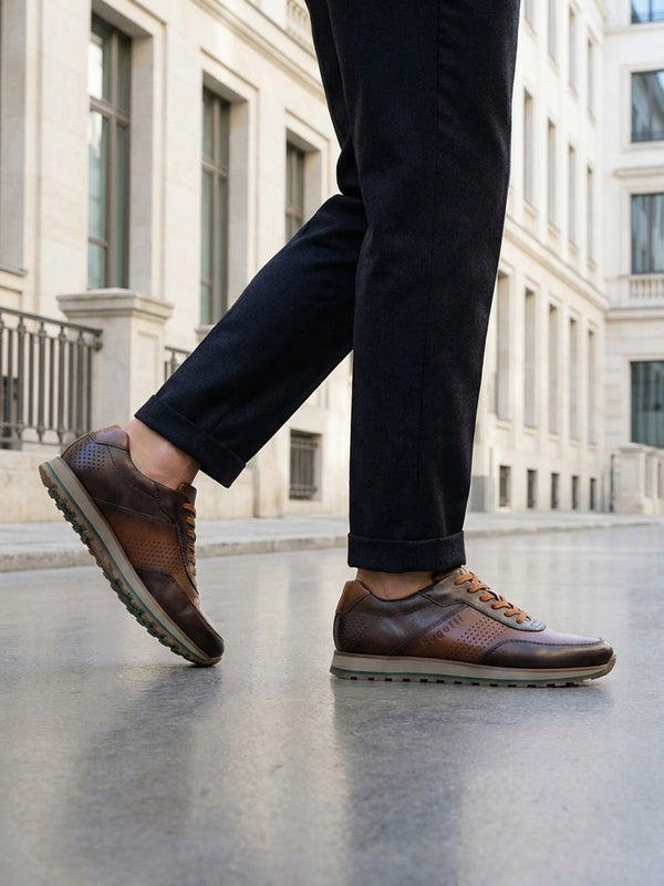 Lifestyle view of bugatti Garnet Evo dark brown premium leather sneakers with dark pants on a city street.