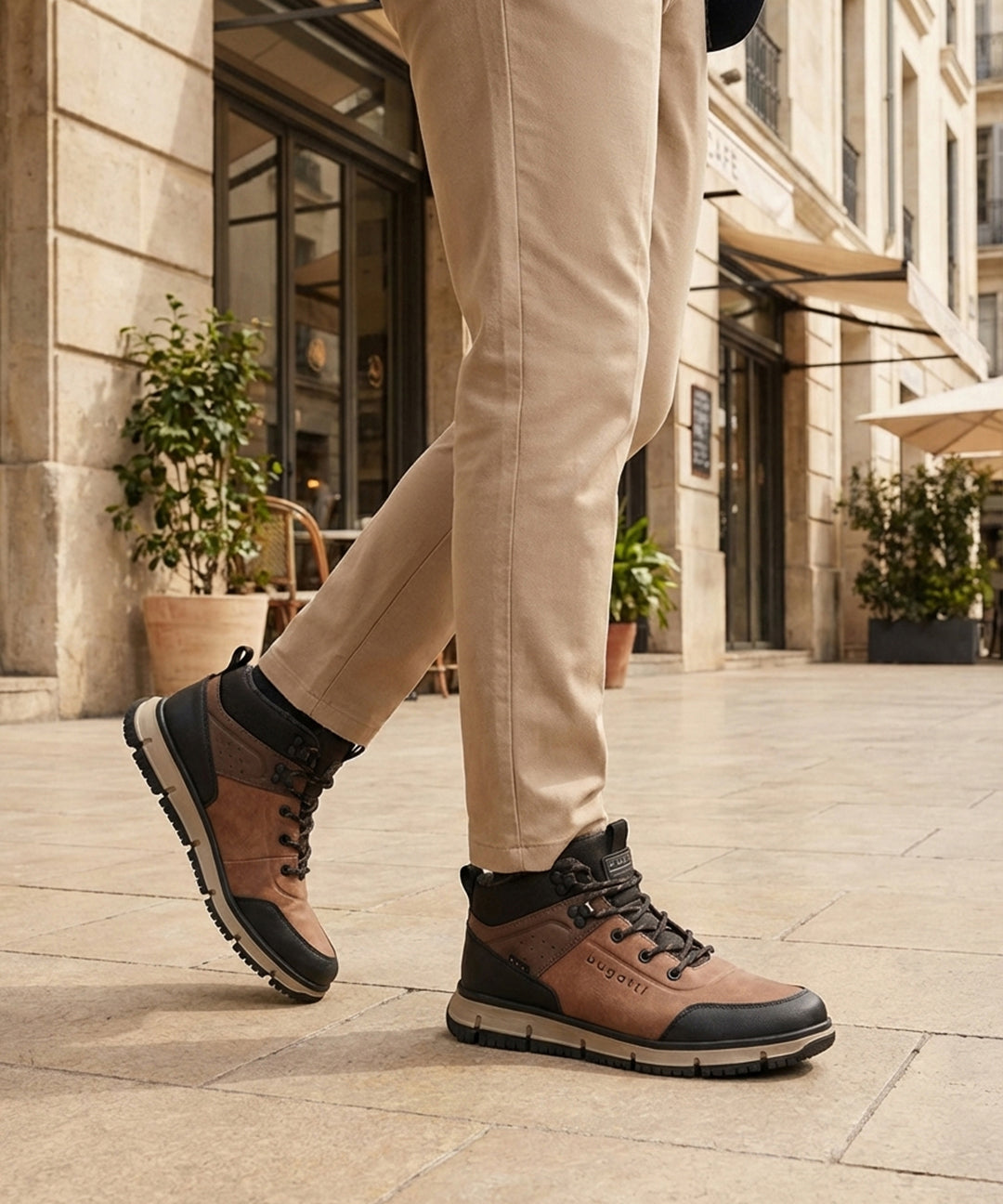 Person wearing A cognac Men's bugatti Outdoor Sneakers featuring a round toe plain toe, zero heels heel. Made from synthetic with a durable eva outsole, this laces design offers both style and comfort. on a city street.