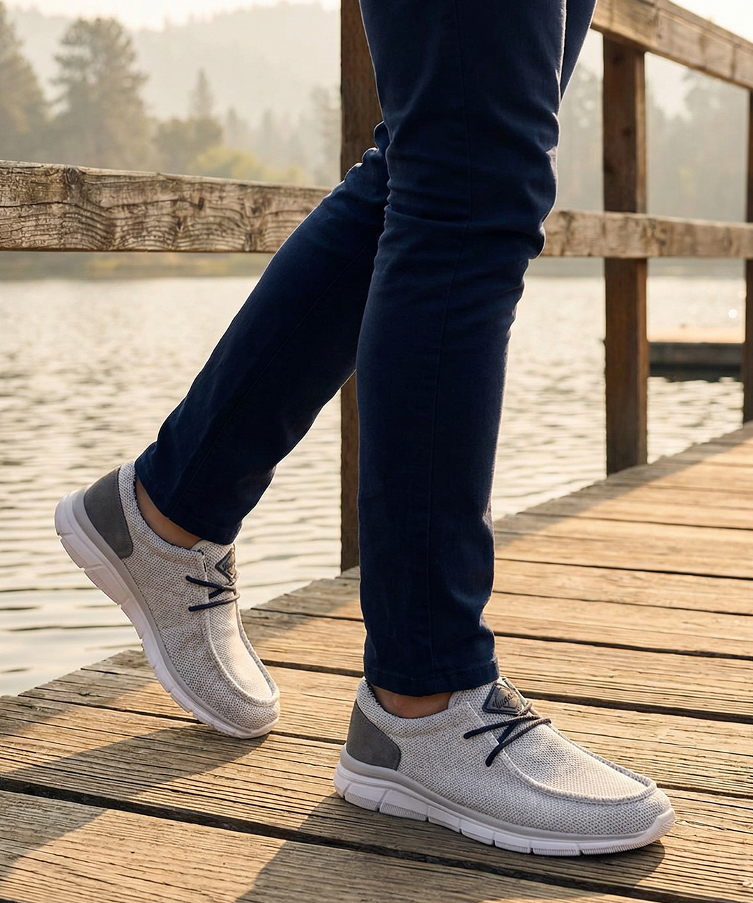 Lifestyle image of bugatti Soa light gray comfort mid-top sneakers with a gray heel patch, worn with navy pants.
