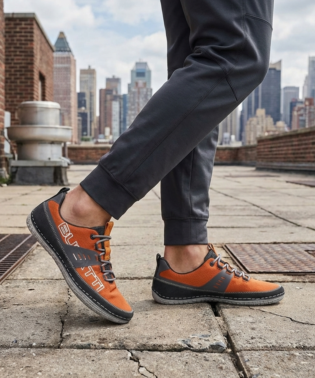 Lifestyle image of bugatti Bimini orange comfort low top sneakers with gray trim and gray laces.
