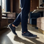Lifestyle shot of bugatti Bimini dark blue low top sneakers with white soles, paired with blue trousers.
