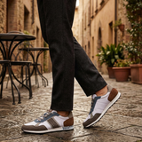 Lifestyle view of bugatti Ross multicoloured sneakers with grey and brown accents, styled with black trousers.