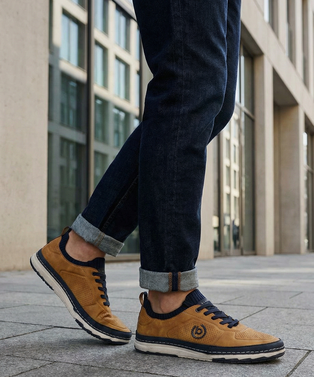 Lifestyle shot of the bugatti Vanadium Yellow comfort low-top sneakers on a person wearing dark jeans with rolled cuffs.