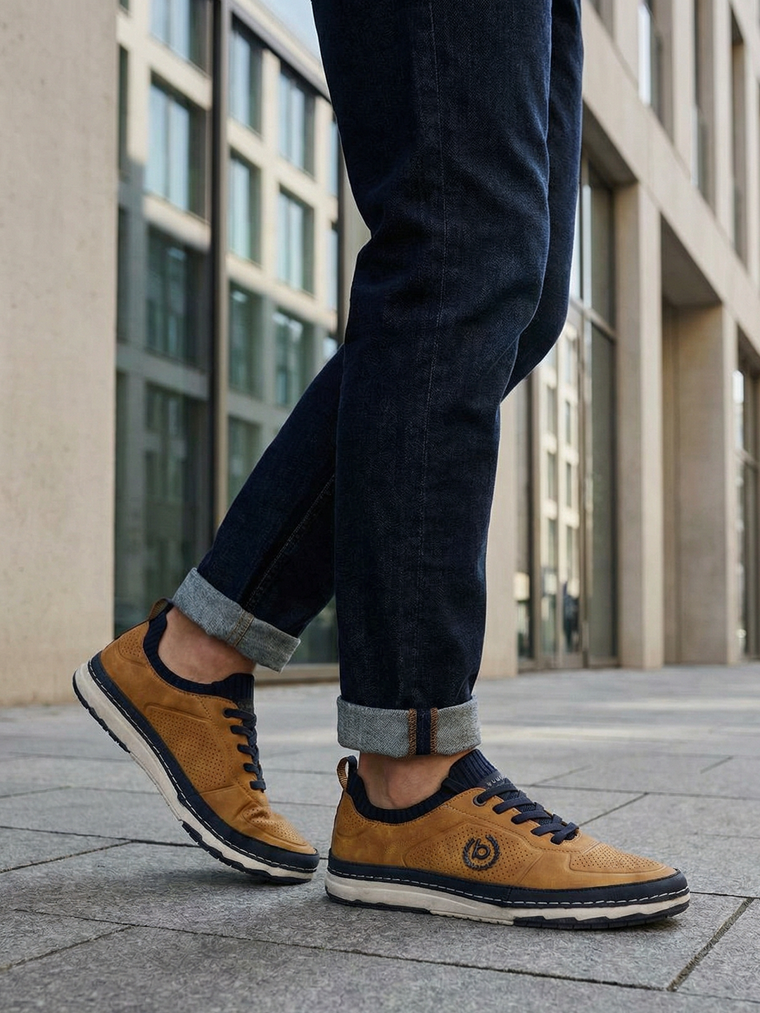 Lifestyle shot of the bugatti Vanadium Yellow comfort low-top sneakers on a person wearing dark jeans with rolled cuffs.