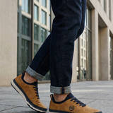 Lifestyle shot of the bugatti Vanadium Yellow comfort low-top sneakers on a person wearing dark jeans with rolled cuffs.