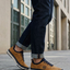 Lifestyle shot of the bugatti Vanadium Yellow comfort low-top sneakers on a person wearing dark jeans with rolled cuffs.
