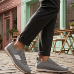 Lifestyle close-up of bugatti Vanadium Grey Comfort Low Top Sneakers worn with grey pants and on a cobblestone street.
