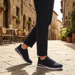 Lifestyle image of bugatti Yucatan dark blue comfort sneakers with a white sole and knitted texture, paired with dark pants.
