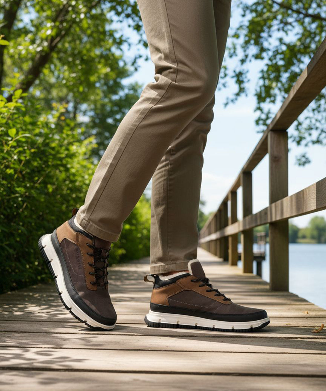 Brown and tan comfort casual boots by Bugatti, styled with a white midsole and worn with khaki trousers on a wooden boardwalk.
