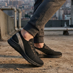 Lifestyle image of bugatti Soa black mid-top sneakers with a grey accent, paired with grey joggers.