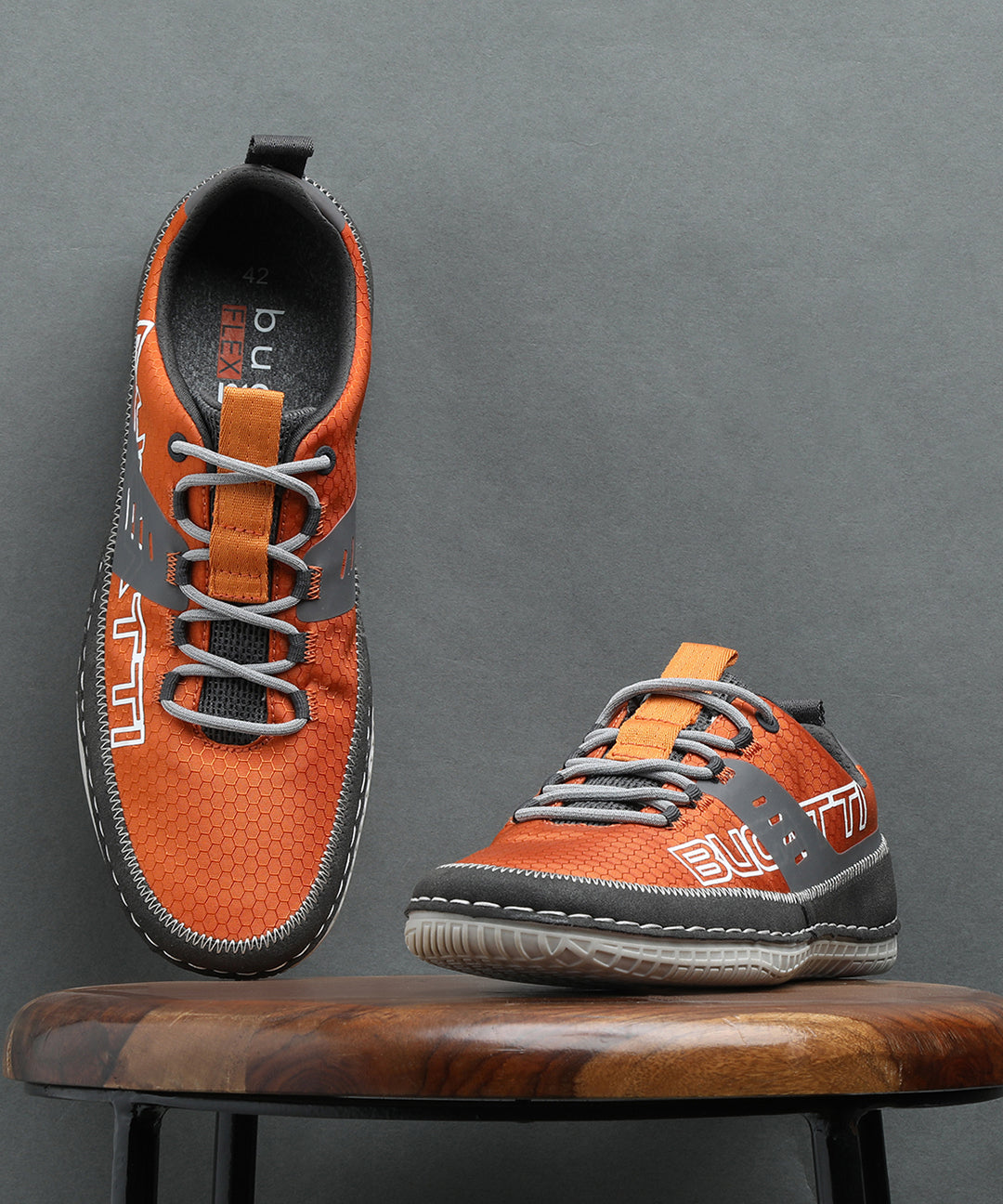 Orange comfort low-top sneakers by bugatti with gray accents and textured patterned details.