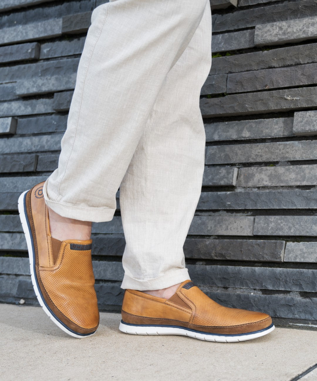 A cognac Men's bugatti Casual Loafers featuring a round plain toe, zero heels heel. Made from premium genuine leather with a durable tr outsole, this slip-on design offers both style and comfort.
