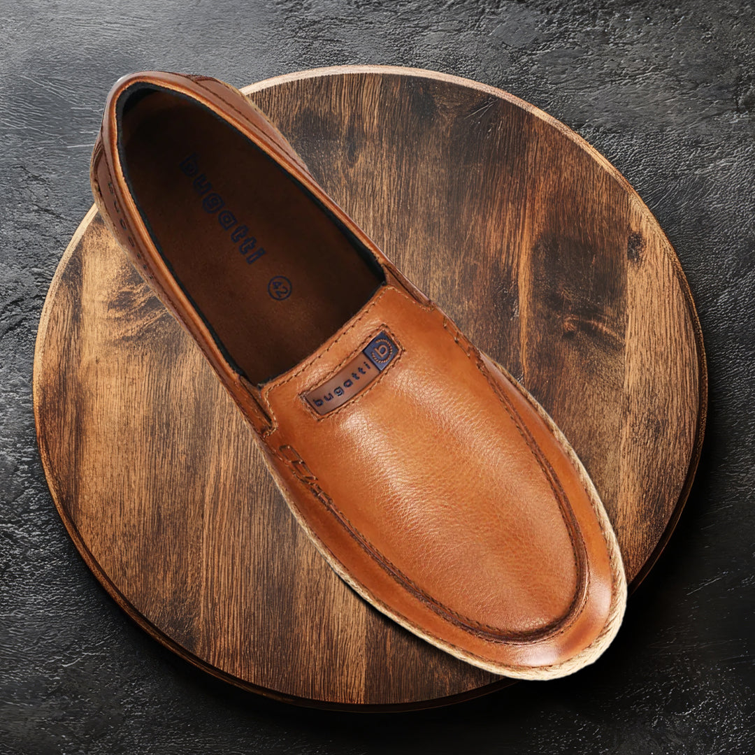 A cognac Men's bugatti Casual Loafers featuring a round toe apron toe, zero heels heel. Made from premium genuine leather with a durable tpr outsole, this slip-on design offers both style and comfort.