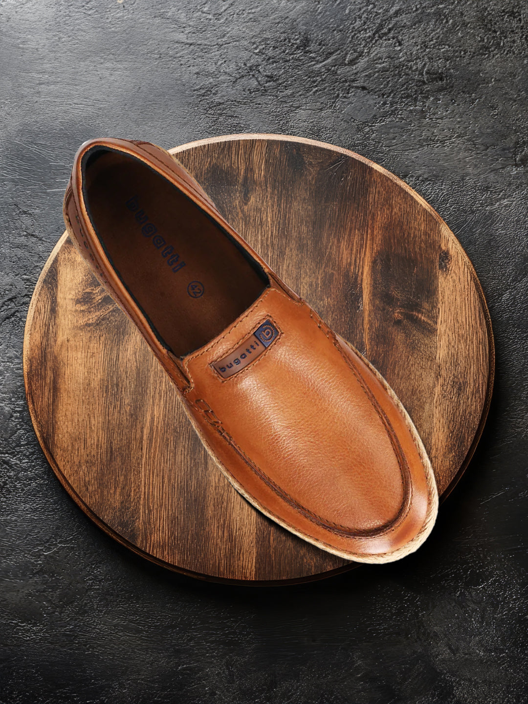 A cognac Men's bugatti Casual Loafers featuring a round toe apron toe, zero heels heel. Made from premium genuine leather with a durable tpr outsole, this slip-on design offers both style and comfort.